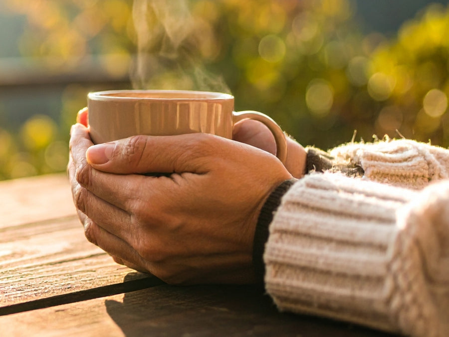 Hands around a warm mug in morning light